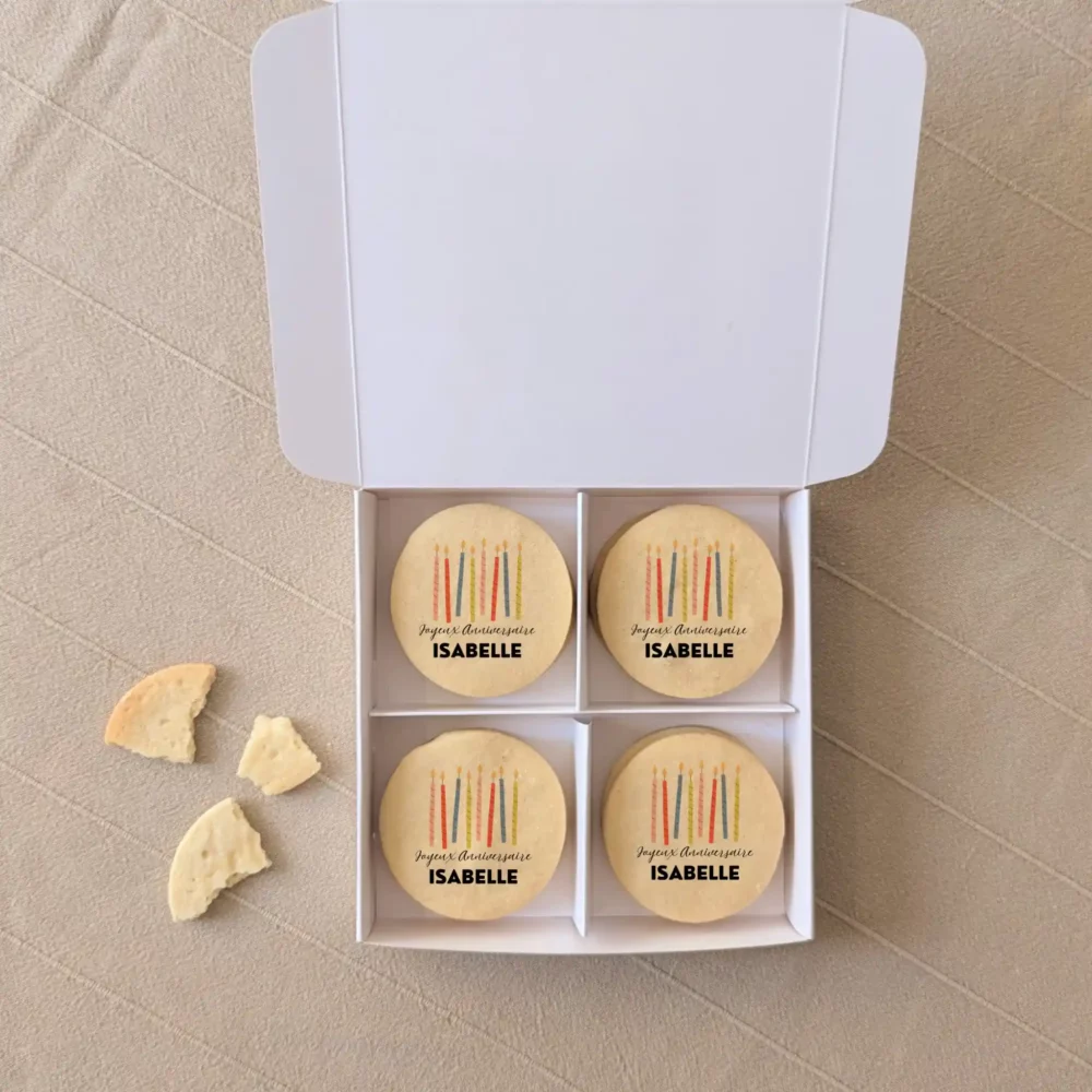 Coffret blanc avec quatre biscuits sablés personnalisés “Joyeux anniversaire Isabelle” imprimés en couleurs, cadeau gourmand original.