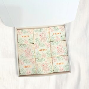 Coffret de 9 guimauves artisanales décorées de fleurs et du mot “Merci”, cadeau gourmand de remerciement.