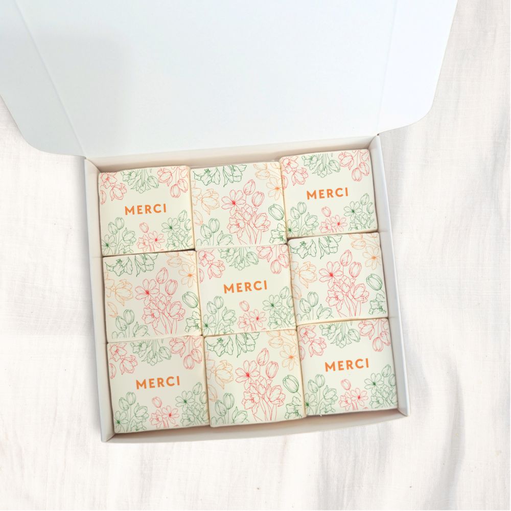 Coffret de 9 guimauves artisanales décorées de fleurs et du mot “Merci”, cadeau gourmand de remerciement.