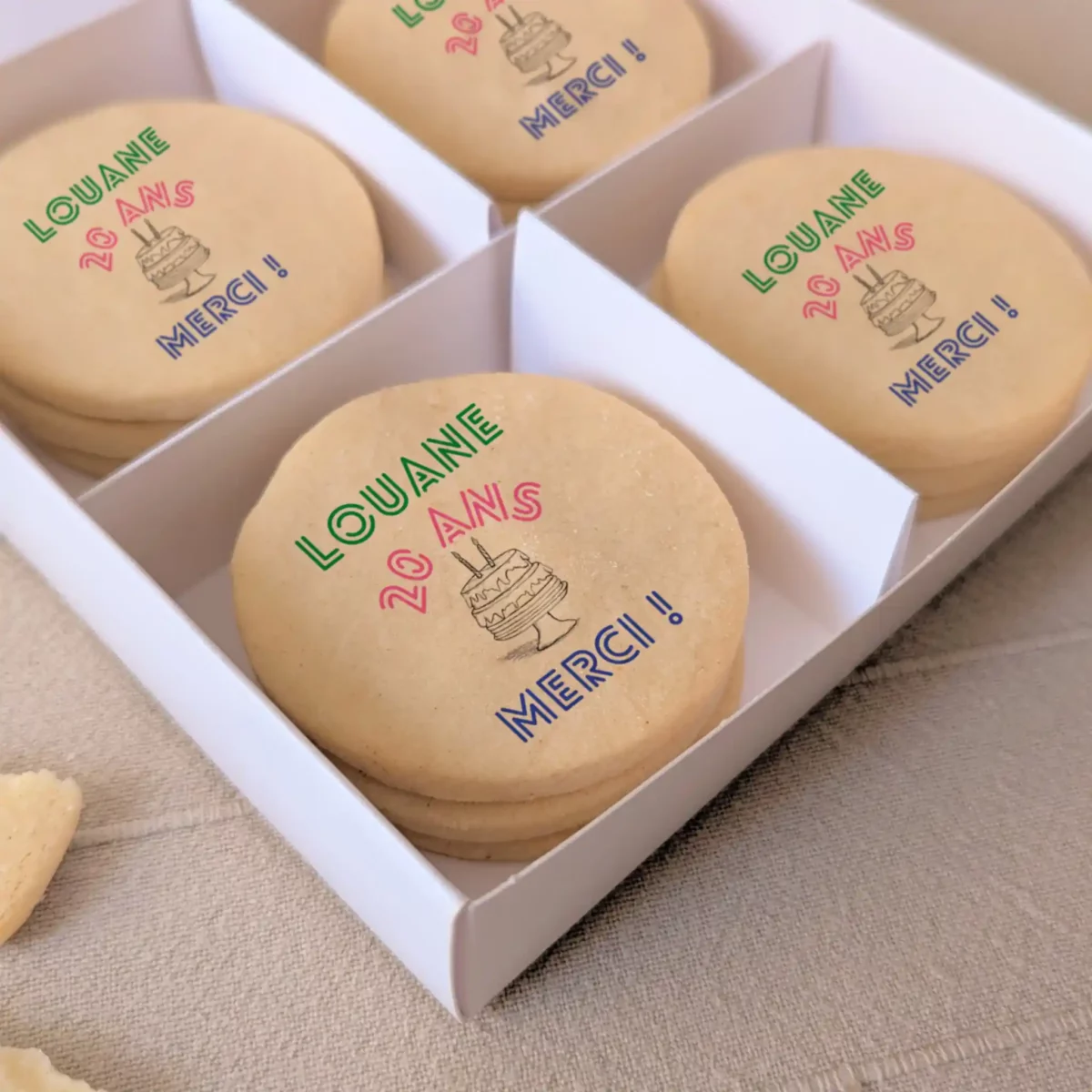 Coffret blanc de biscuits sablés personnalisés avec prénom “Gustave 2 ans” et motifs festifs imprimés.