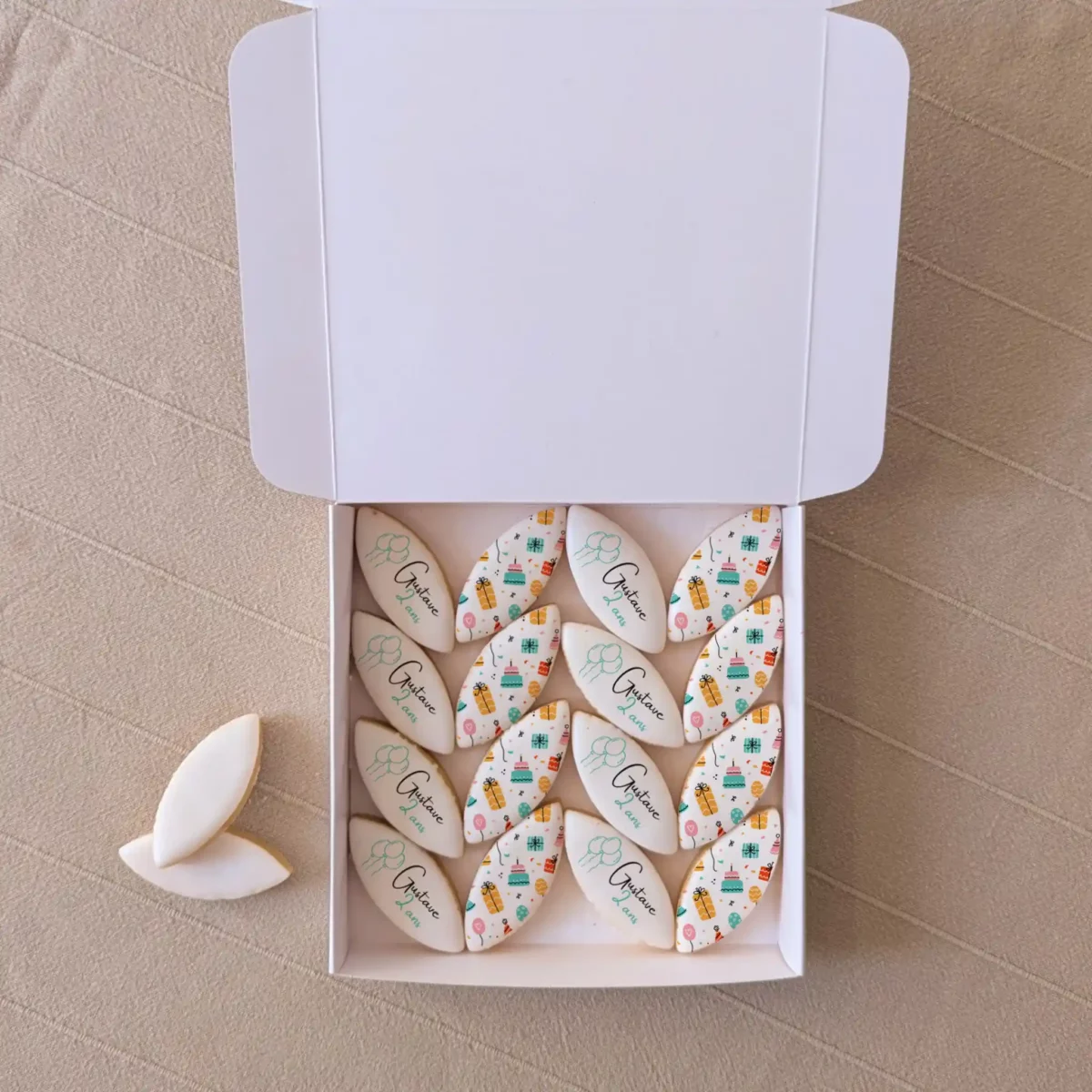 Coffret L’Aixois – 16 calissons personnalisés pour anniversaire Coffret cartonné blanc contenant seize calissons imprimés “Joyeux anniversaire Isabelle”, gourmandise provençale personnalisée.